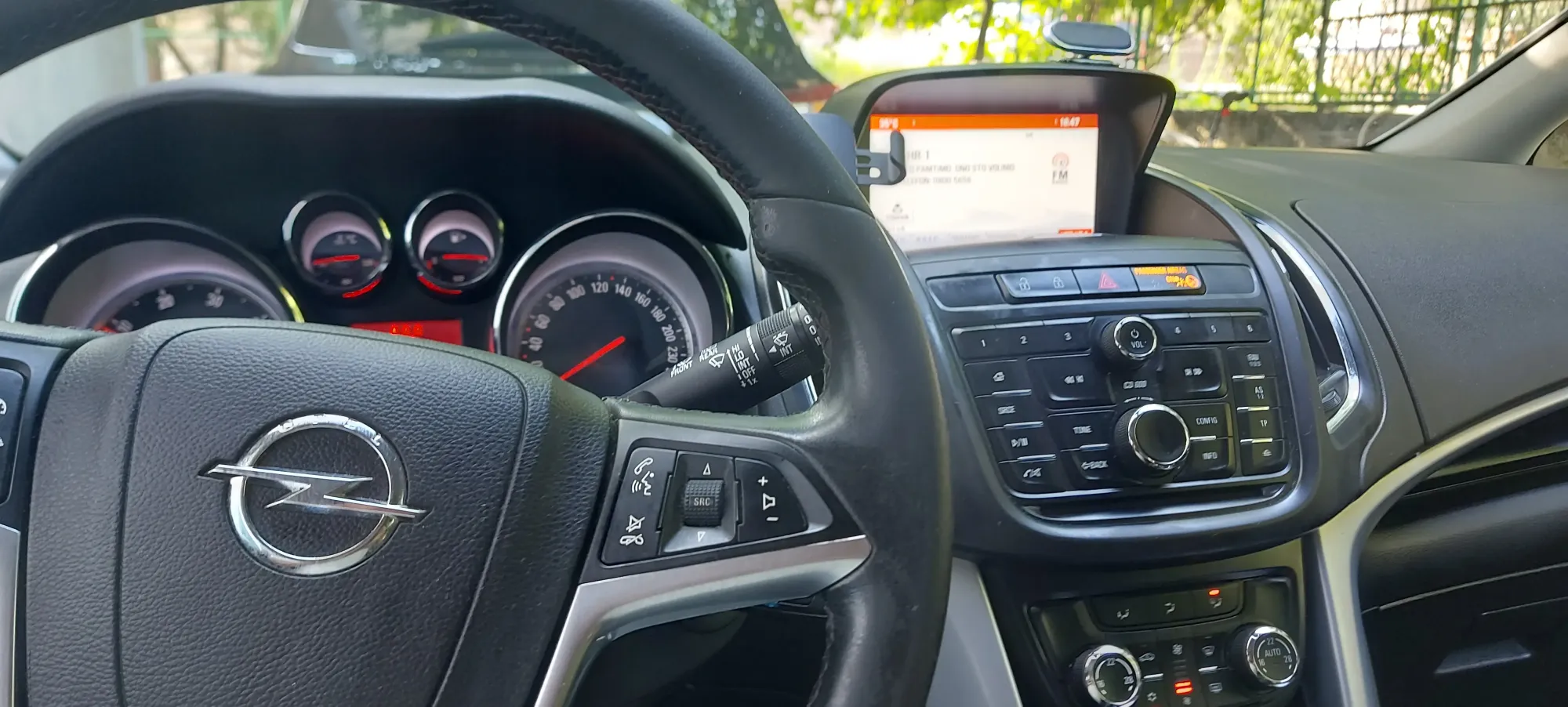 Standard taxi car cockpit showing the steering wheel, instrument dials and dashboard navigation screen